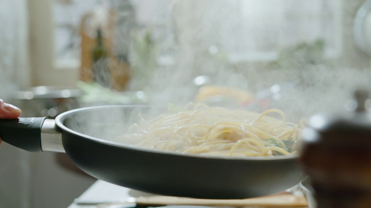 厨师在煎锅里炒菜拌面食视频素材