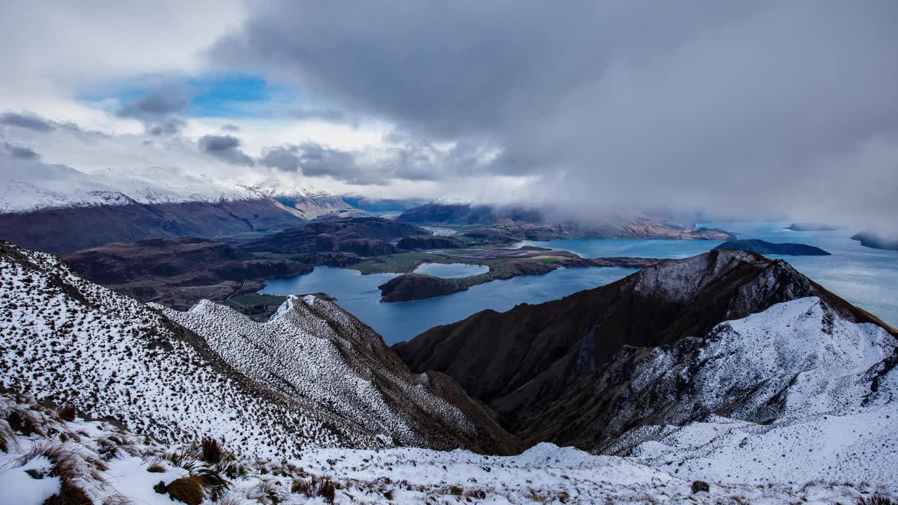 延时拍摄的新西兰罗伊斯山顶上的山景，云层和阳光在湖面上移动视频素材