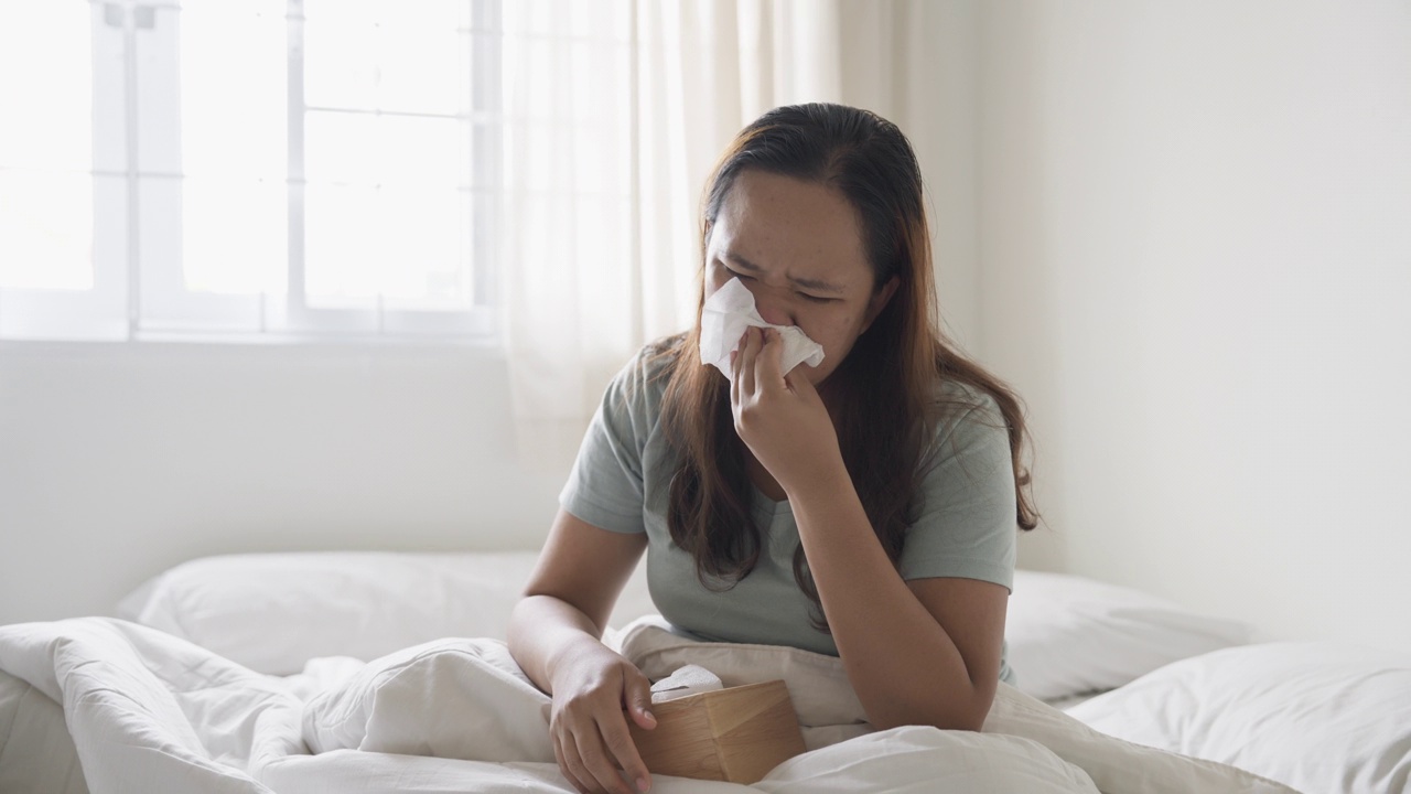 沮丧的生病的女人坐在床上视频素材