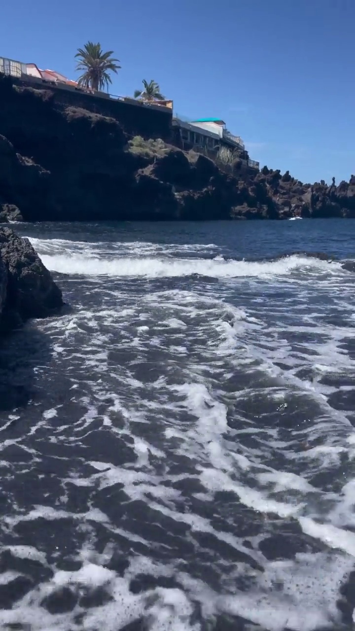 西班牙特内里费岛，海浪拍打着黑色火山沙的海岸。视频下载