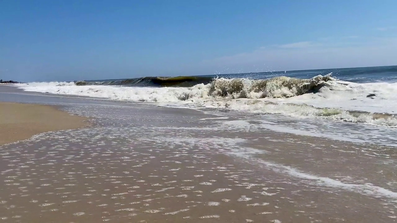 低角度拍摄的海浪翻滚到纽约火岛的海岸视频素材