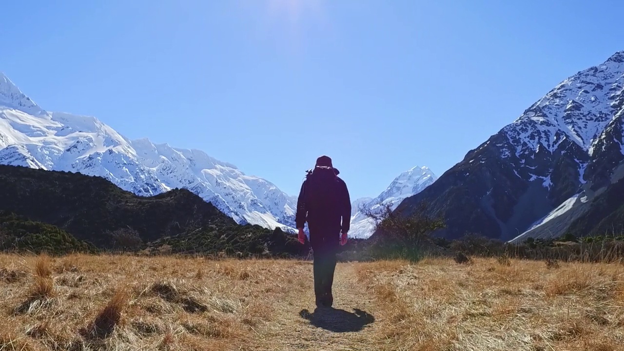 一个年轻人背着背包走在山间小路上视频素材