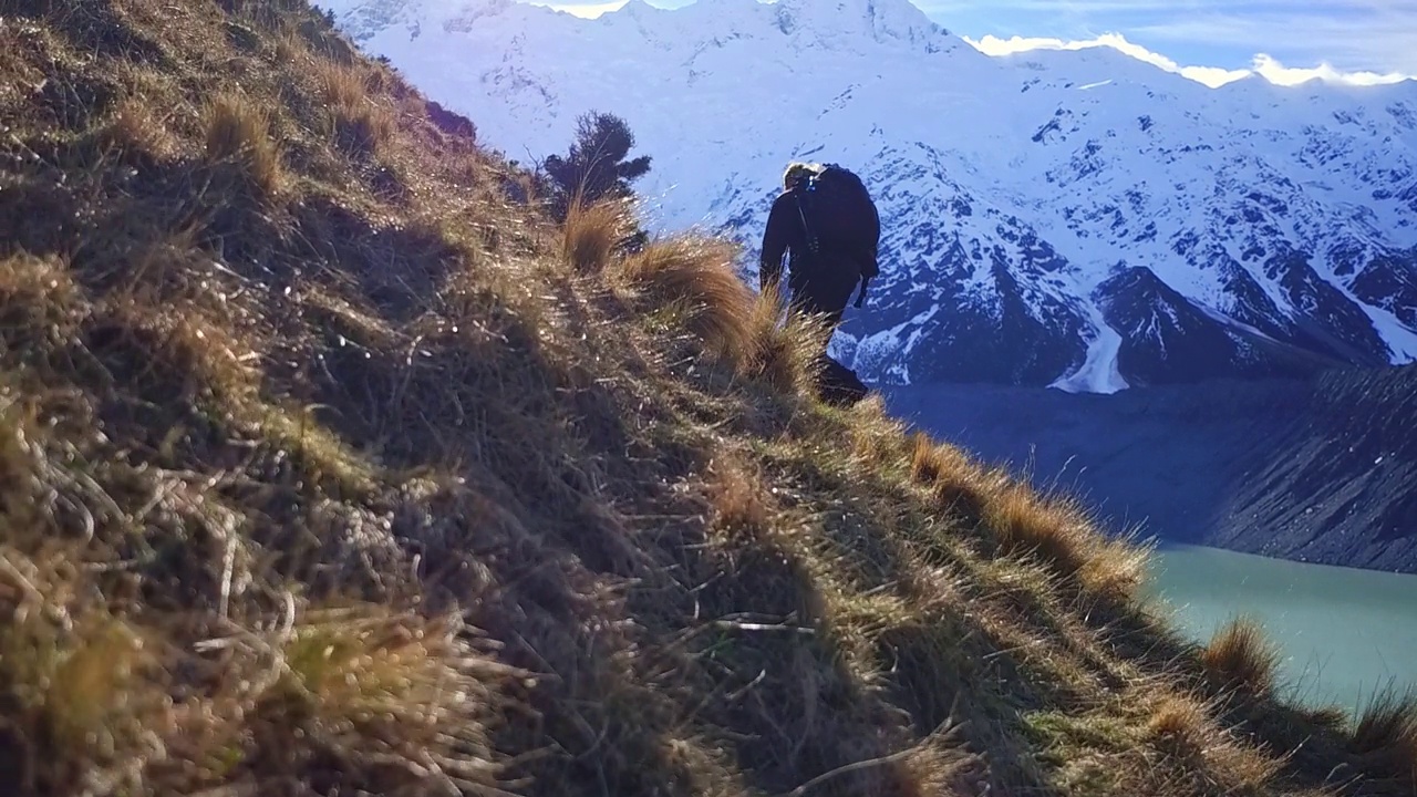 一个年轻人背着背包和摄影器材踏上了登山之旅视频素材