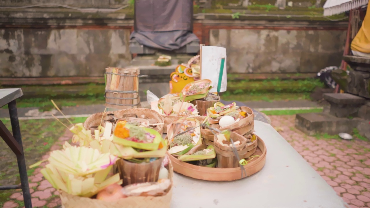 在巴厘岛寺庙里，传统的巴厘岛祭品包括鲜花和水果。印度教庆典。视频下载