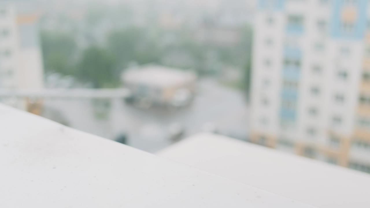 倾盆大雨，大雨，模糊。从公寓大楼的窗户看出去的风景。水珠落在排水系统上，溅起水花。视频素材