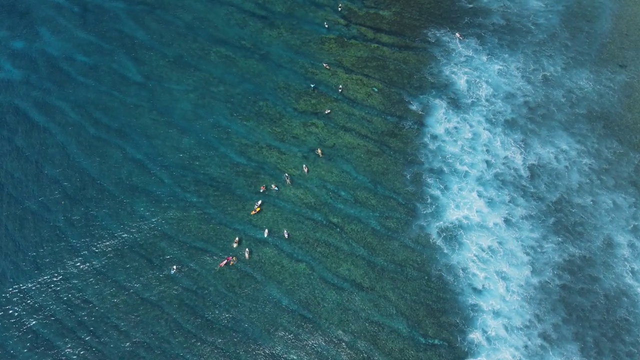 在海洋中冲浪的冲浪者鸟瞰图。在透明的海洋里，完美的海浪和冲浪者视频素材