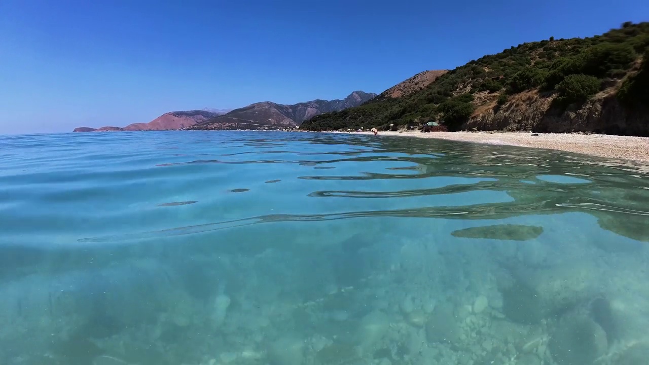 在清澈的绿松石海水中潜水，靠近白色的鹅卵石沙滩，暑假活动，浮潜和游泳视频素材