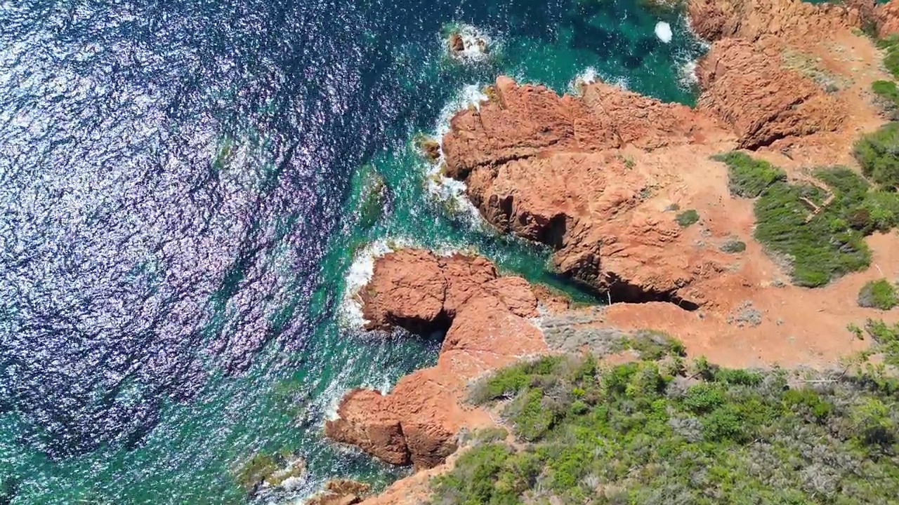 无人机飞过岩石海岸和蓝色的海水视频素材