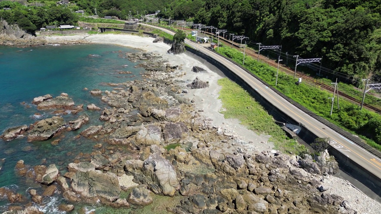 无人机拍到的海岸线后面有树的狭窄道路视频素材