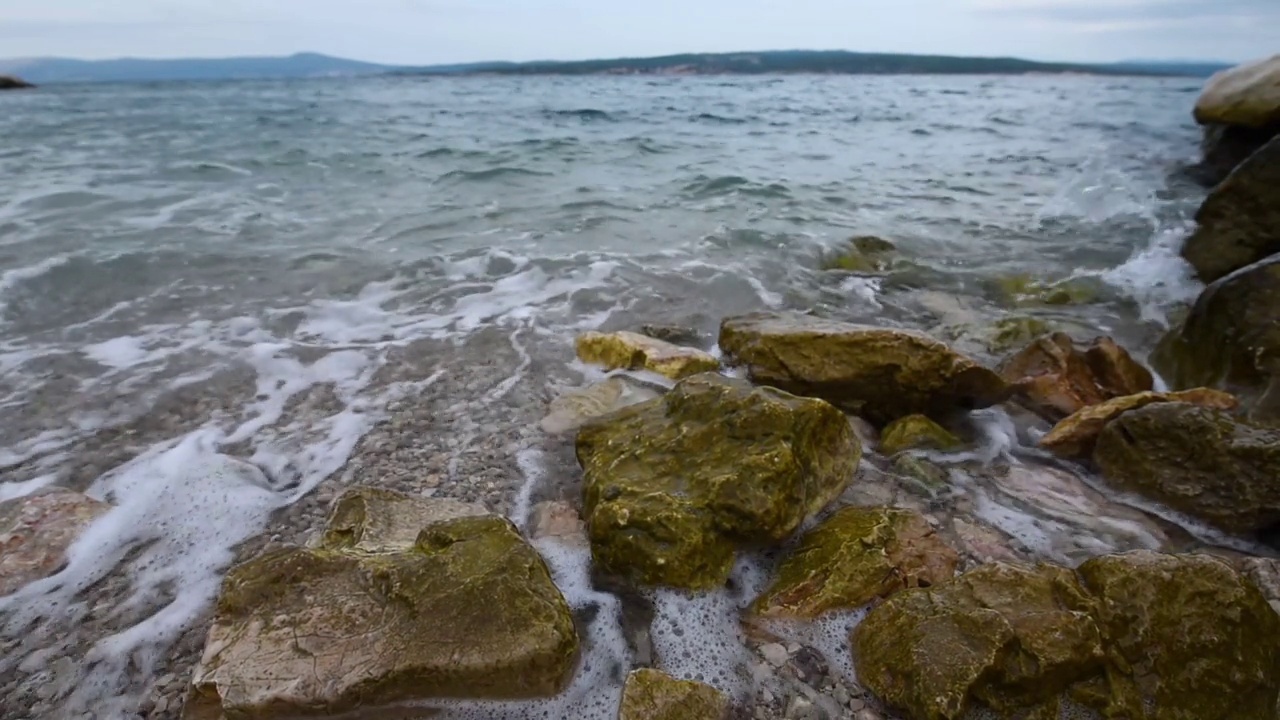 海浪在亚得里亚海克罗地亚海滩的岩石海岸线上破碎视频素材