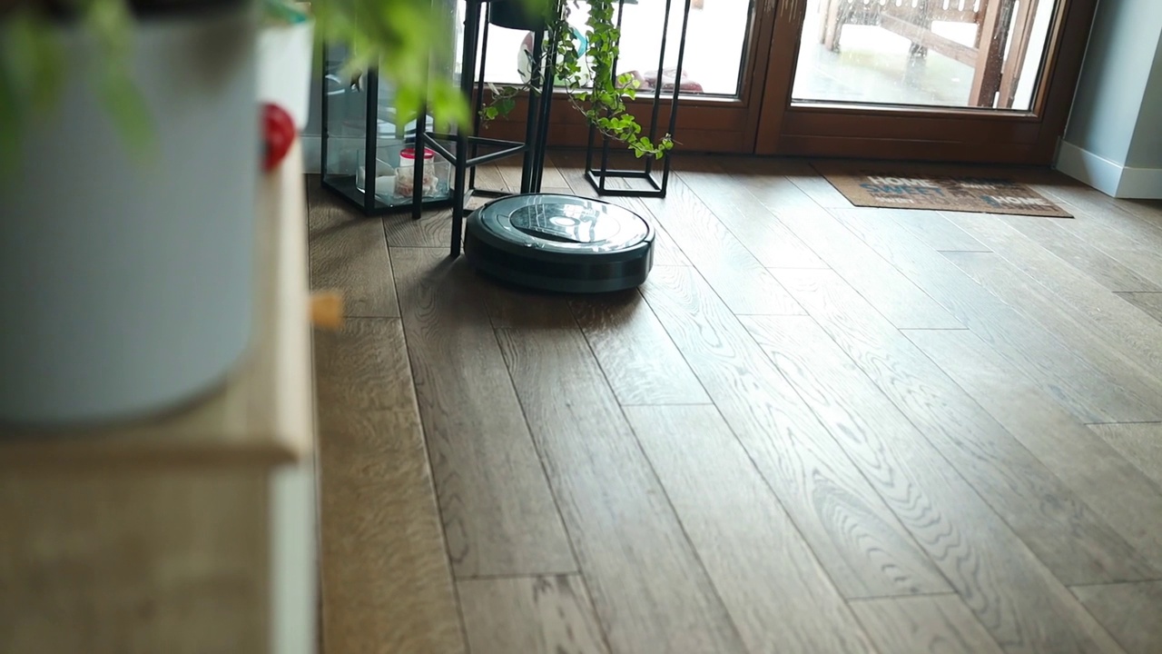机器人吸尘器正在卧室里吸尘。拥有自动化设备的智能家居，简化生活。智能吸尘器可以清洁地板。视频素材