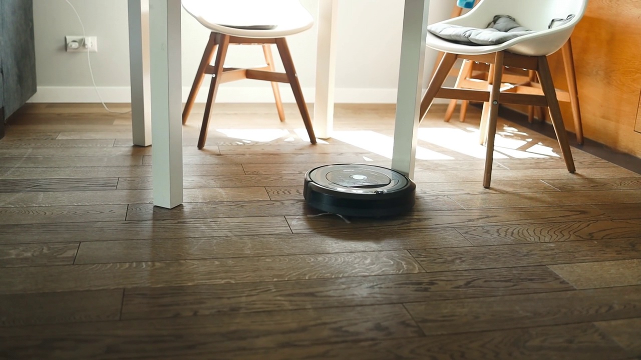 机器人吸尘器正在卧室里吸尘。拥有自动化设备的智能家居，简化生活。智能吸尘器可以清洁地板。视频素材