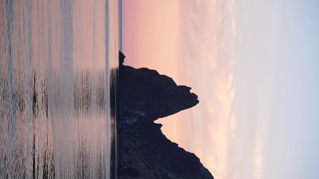 垂直鸟瞰平静蔚蓝的大海和火山岩海岸。小波浪在水面上的运动模糊。自然夏天海洋大海沙滩背景。没有人。度假、度假、旅游的概念视频素材