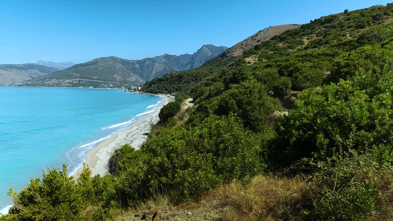 阿尔巴尼亚美丽海岸线的绿色和蓝色全景图，橄榄树，山丘和山脉在令人惊叹的海湾，白色的海滩和蓝绿色的海水视频素材