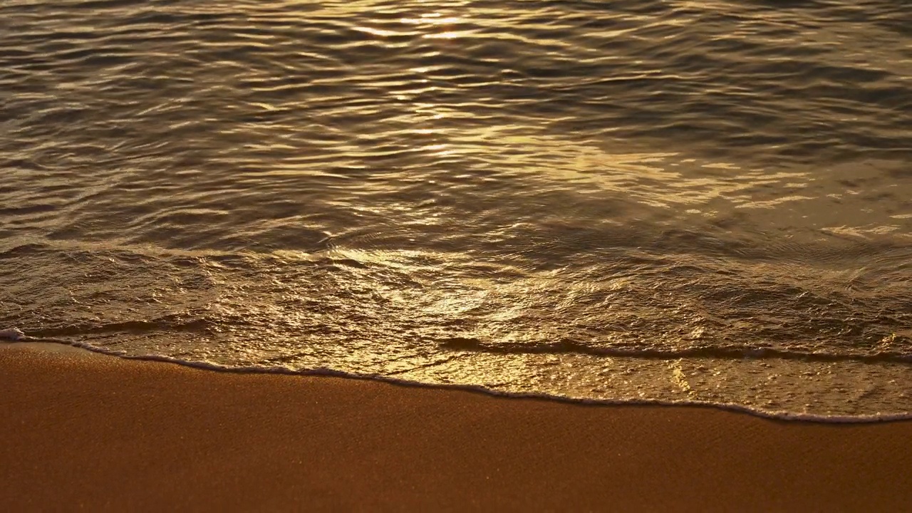 日落的海滨。小浪在岸边翻滚。黄金时代。夕阳的余晖在海水上留下金色的光辉。视频素材