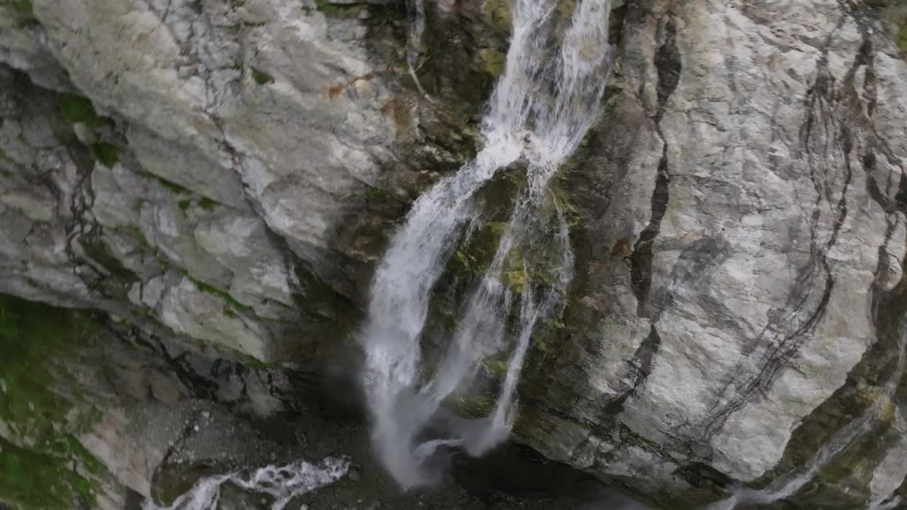 在一个阳光明媚的日子里，高高的山上冰川瀑布的鸟瞰图。4k高瀑布的特写视频素材