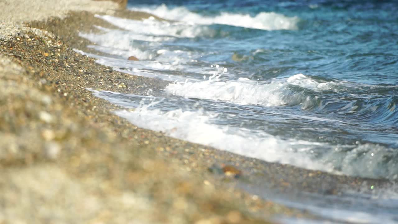 小海浪，模糊的软泡沫海浪冲刷金色卵石沙滩夕阳。海滩上的海浪。没有人。假日休闲概念。抽象航海夏季海洋日落自然背景。视频素材