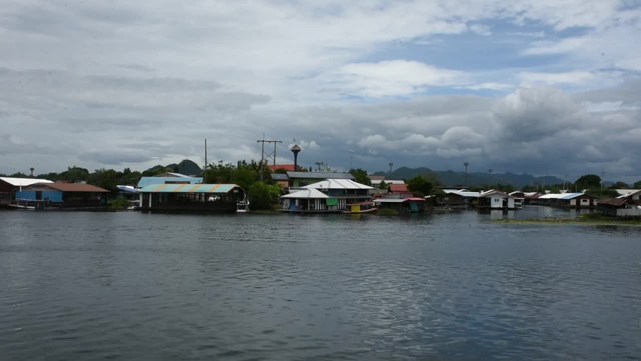 在泰国北碧府的花崖河上漂流着古色古香的家和度假旅馆，欣赏风景西沙瓦河和泰国人的生活视频素材