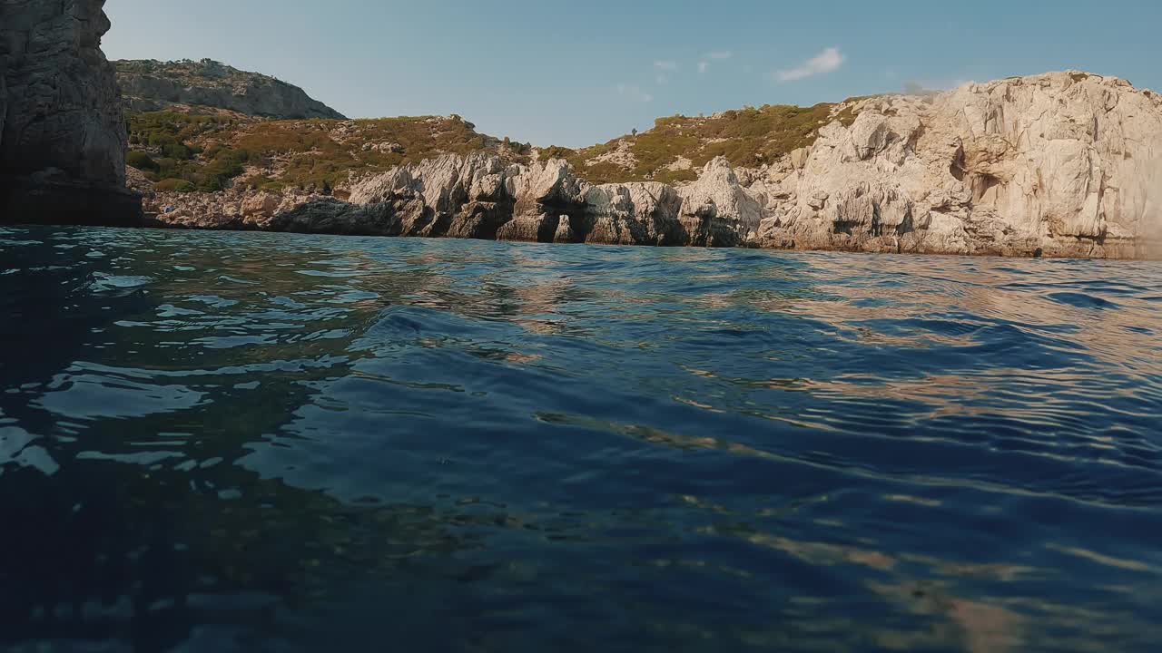 海岸海景与岩石海岸从水位，背光，低角度拍摄视频素材