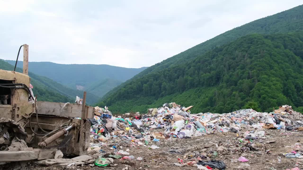 在美丽的青山中间的一个垃圾填埋场。消除塑料垃圾的问题视频素材