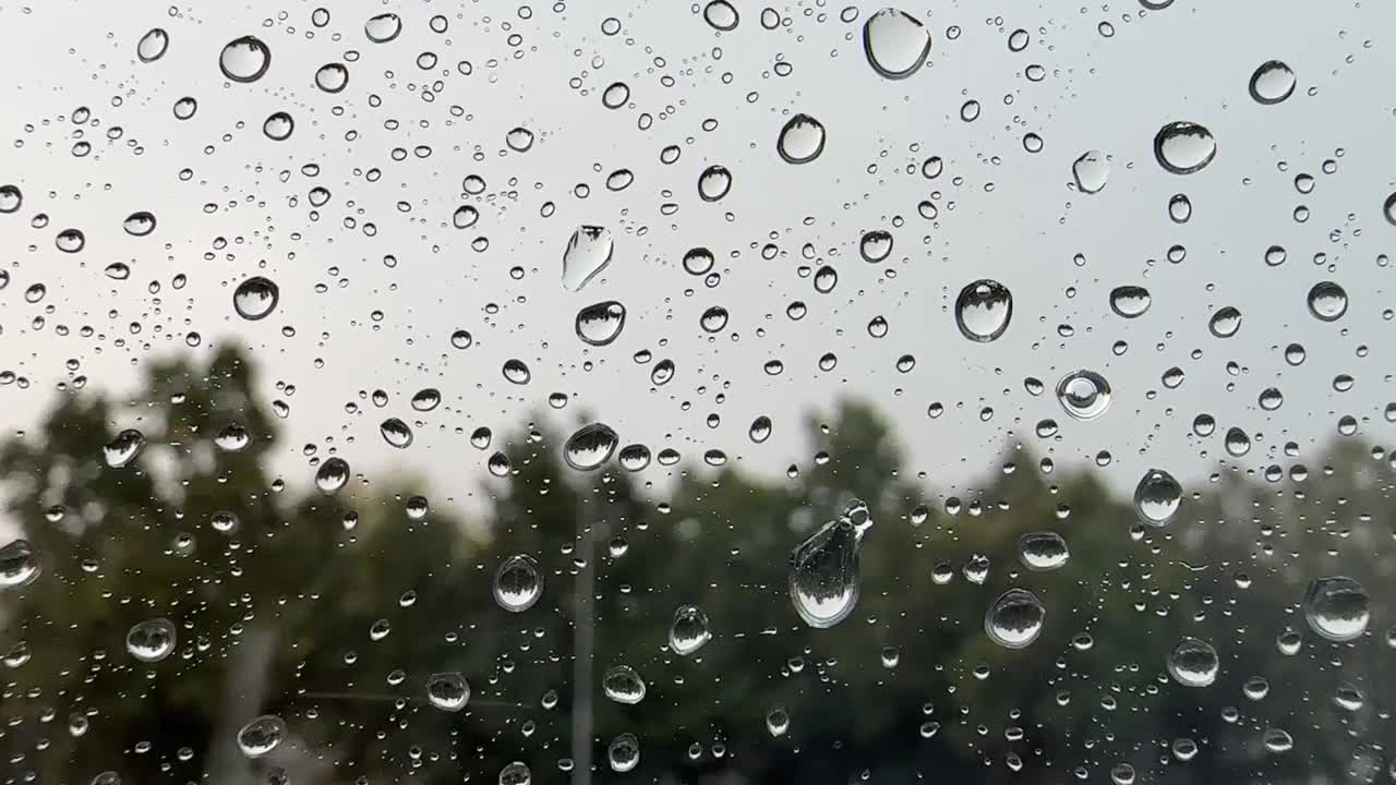 雨落在窗户上。下雨了。雨滴的特写。落下的雨滴。视频下载