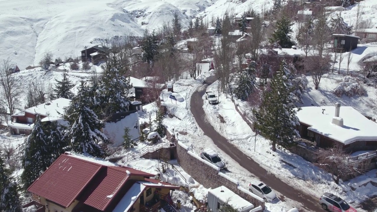 在智利圣地亚哥的安第斯山脉上，从空中俯瞰下雪的Farellones滑雪度假村村庄、酒店、房屋和街道视频素材