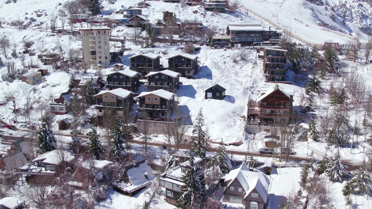 鸟瞰图环绕雪覆盖的Farellones山坡村庄滑雪度假小屋和酒店附近，圣地亚哥，智利视频素材