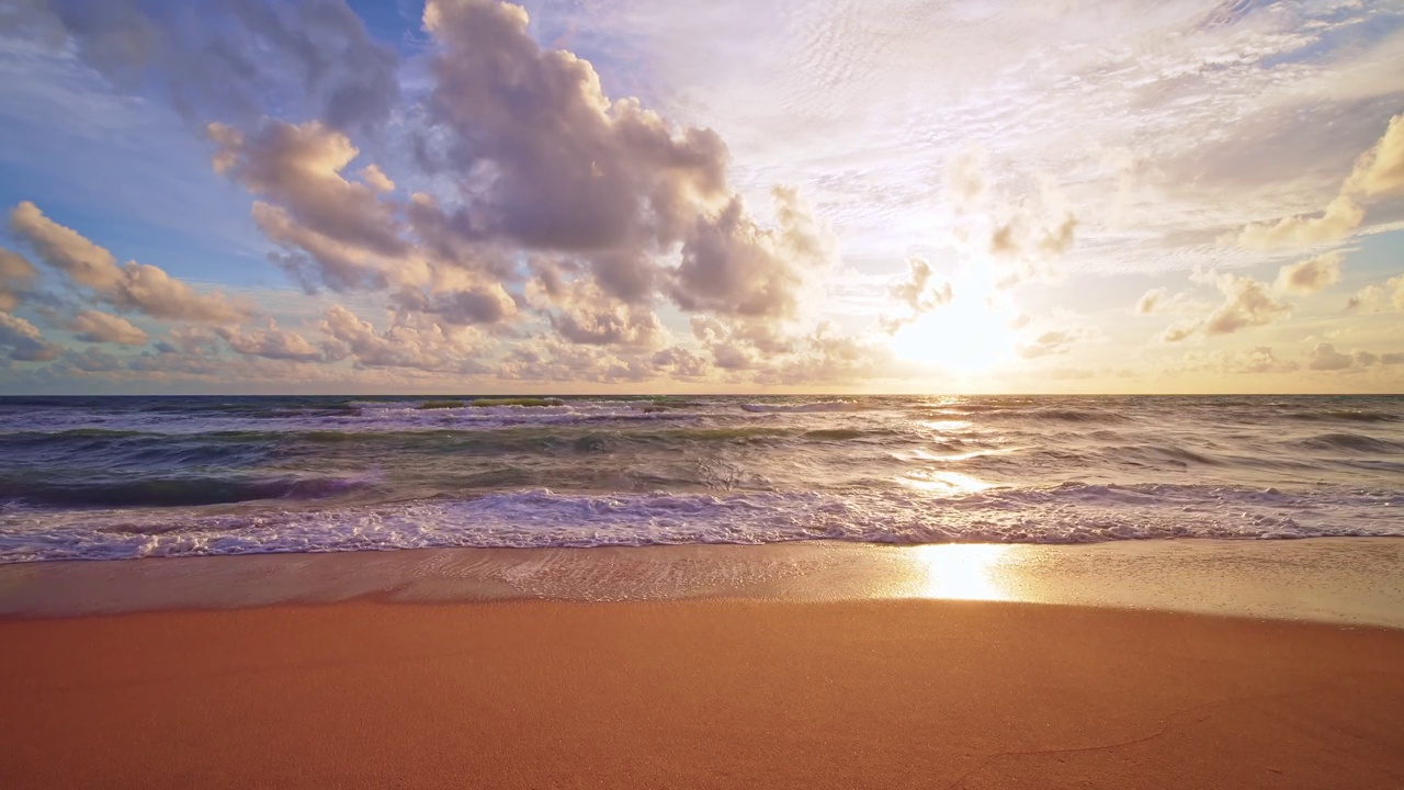 戏剧性的海上日出或日落天空在海上。慢动作海浪金色的天空景观，美丽的海浪冲击沙滩视频素材