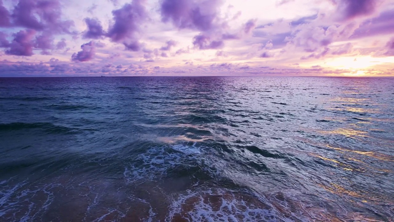 戏剧性的海上日出或日落天空在海上。慢动作海浪金色的天空景观，美丽的海浪冲击沙滩视频素材