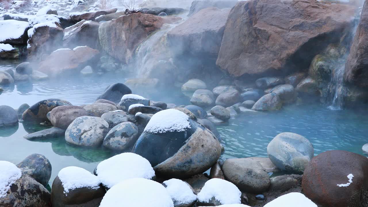 固定的自然场景，水流入热气腾腾的天然温泉被雪包围在科罗拉多州的山区视频素材