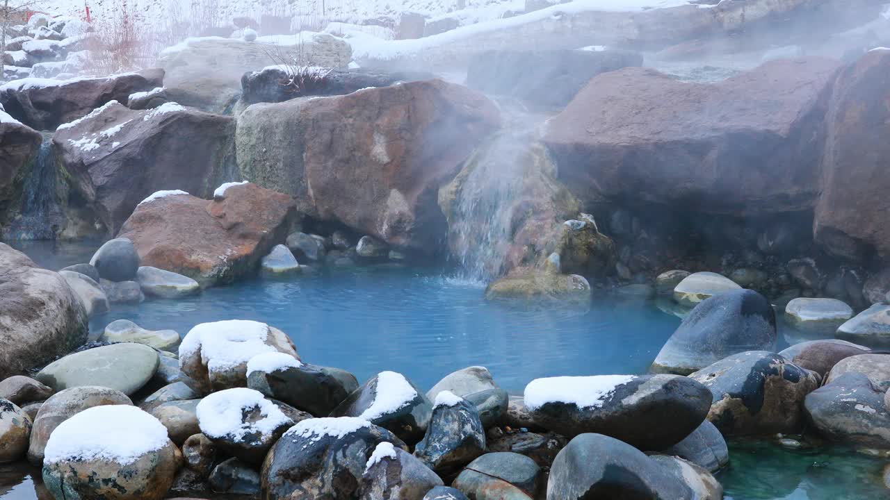 固定的自然场景，水流入热气腾腾的天然温泉被雪包围在科罗拉多州的山区视频素材