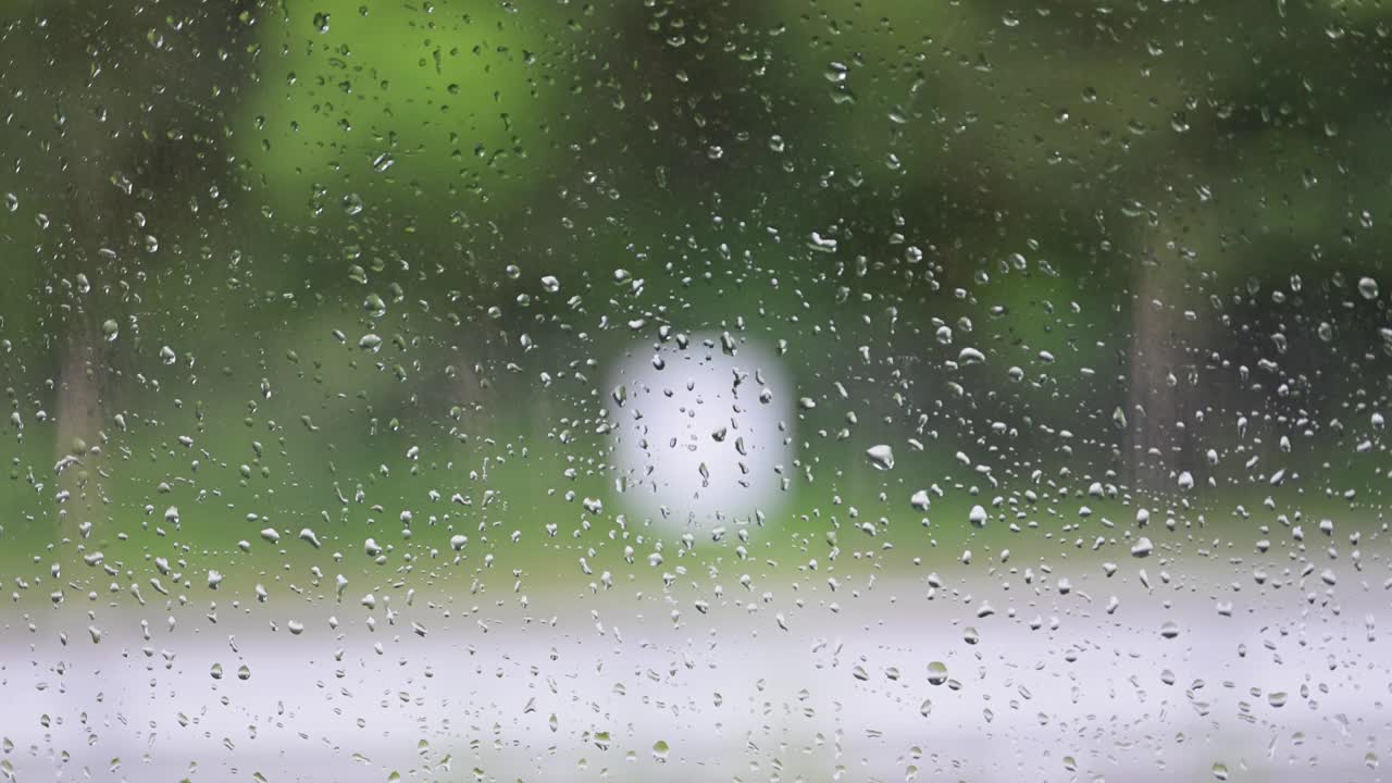 雨中水滴在车窗上的特写视频素材