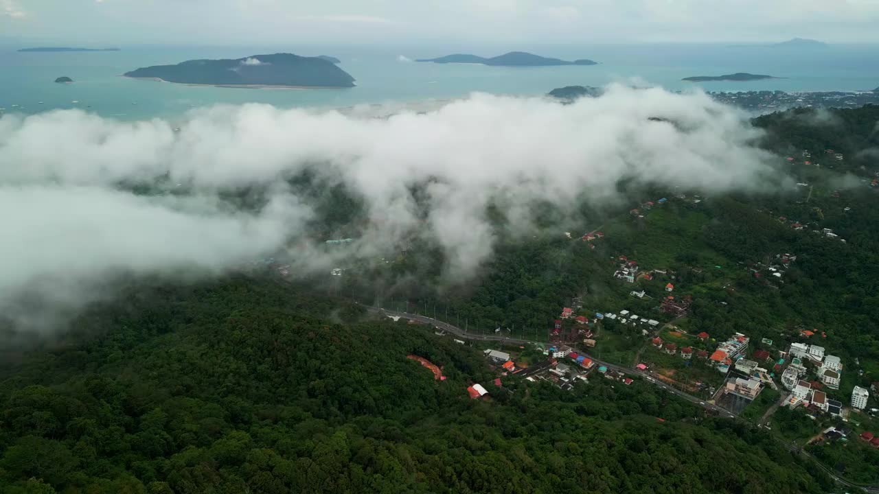 鸟瞰图泰国普吉岛周围的绿色山上笼罩着白雾。视频素材