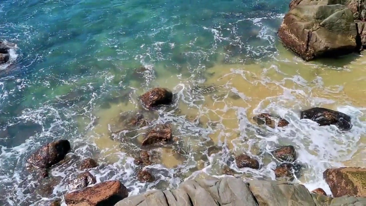 海滩沙滩蓝色绿松石水波浪岩石全景埃斯孔迪多港。视频素材