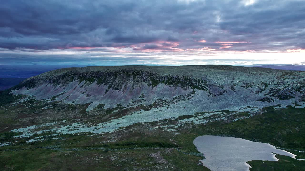 鸟瞰图沿Molnet Nipfjället岩石山山脊和湖泊与充满活力的彩色夜空视频素材