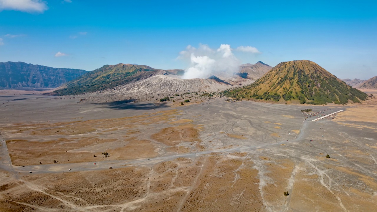 超缩鸟瞰图环绕Bromo火山活火山飞行，汽车将游客运送到印尼爪哇的观景点视频素材