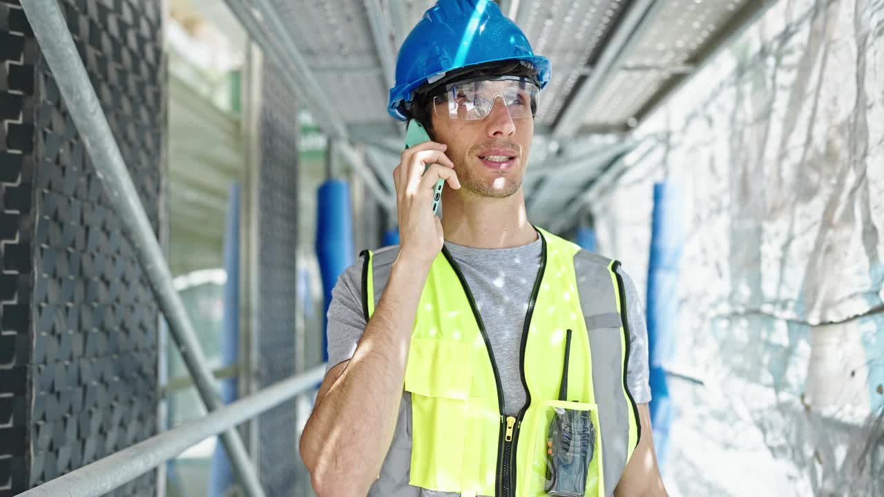 年轻的西班牙裔建筑师在工地用智能手机聊天视频素材