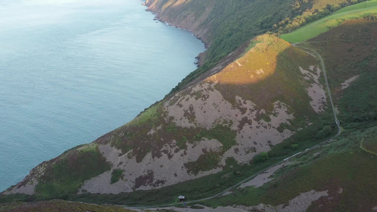 在日落时分，无人机在英国北德文郡的海岸线上倾斜拍摄。视频素材