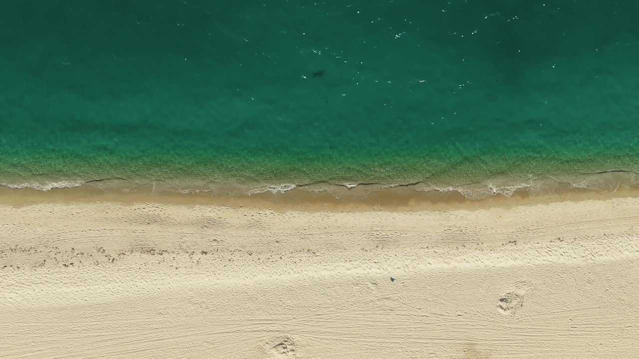 空中拍摄的空旷的沙滩和海浪的海洋。自顶向下射击视频素材