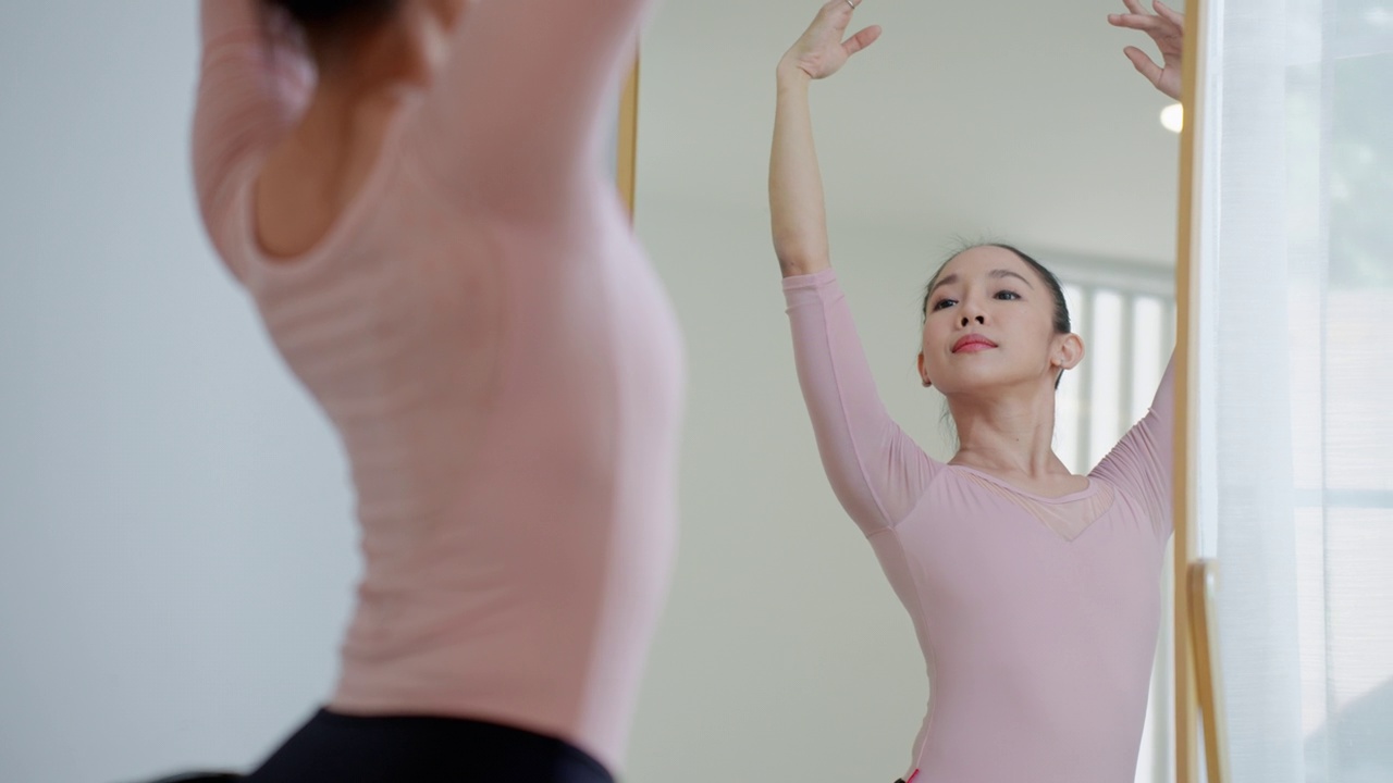 身着粉黑色芭蕾舞裙的美丽女芭蕾舞演员在芭蕾舞工作室排练，成年女芭蕾舞演员上台前的训练，优雅的女芭蕾舞演员表演优美的舞蹈动作视频下载