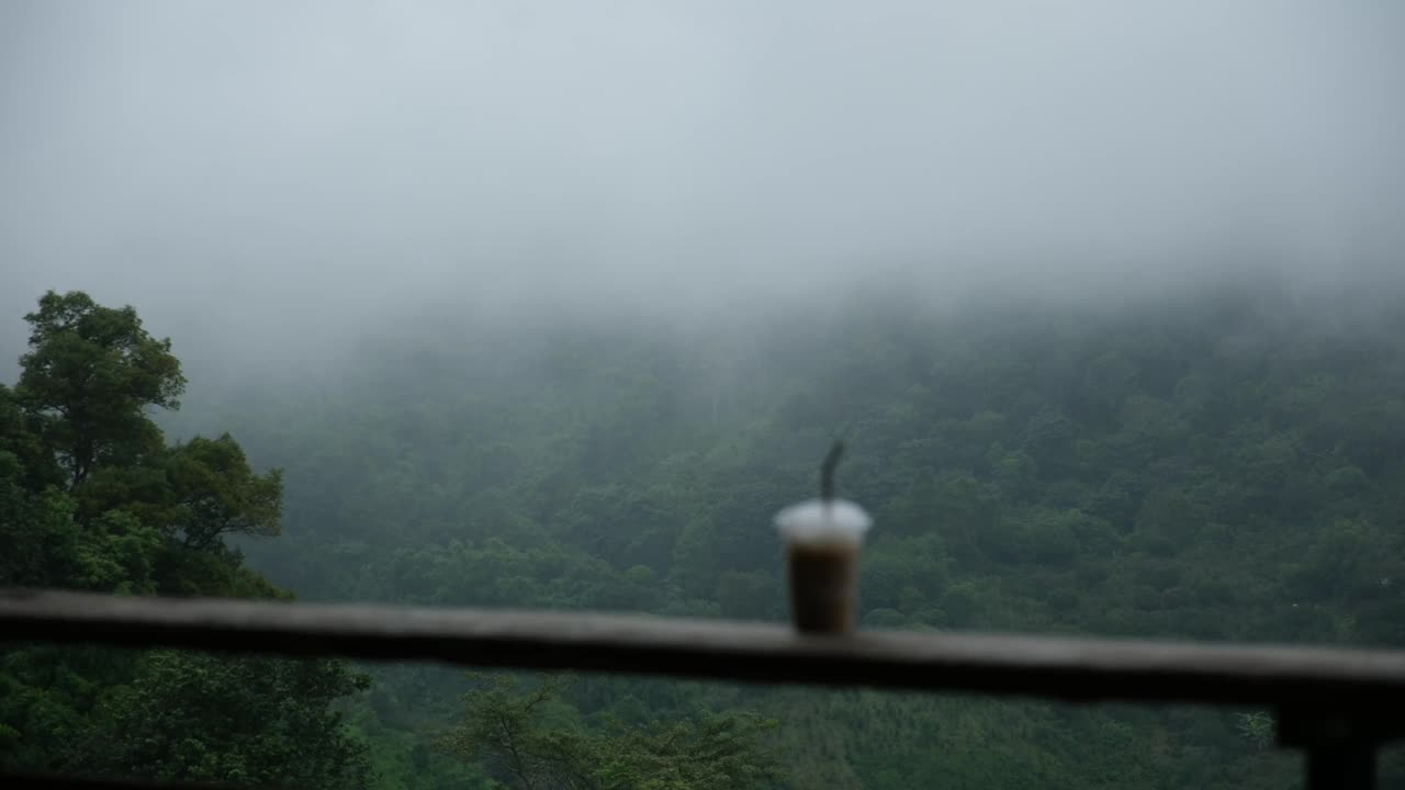 雾气蒙蒙的日子里，在山景的木阳台上喝一杯热咖啡视频素材