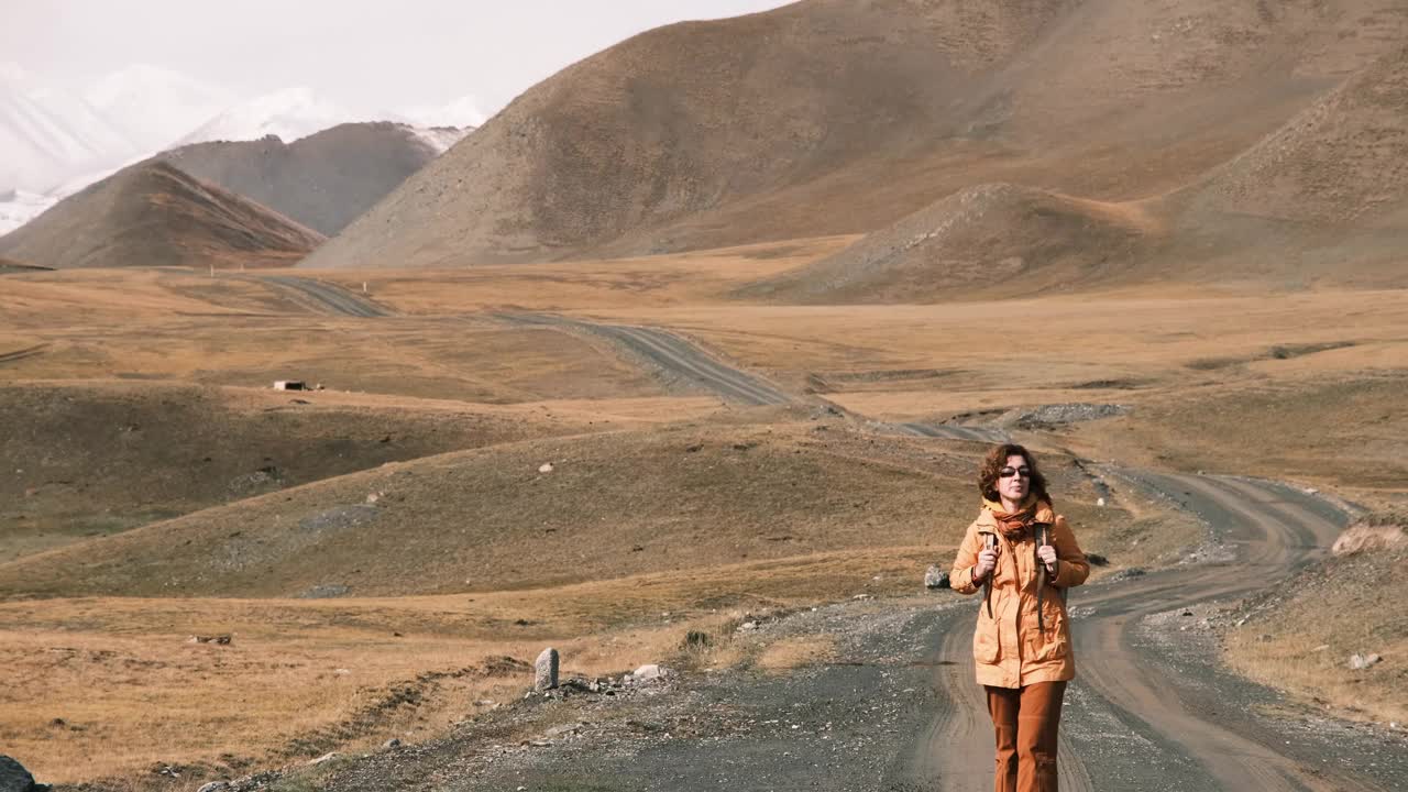 女游客走在土路上欣赏天山美景视频素材