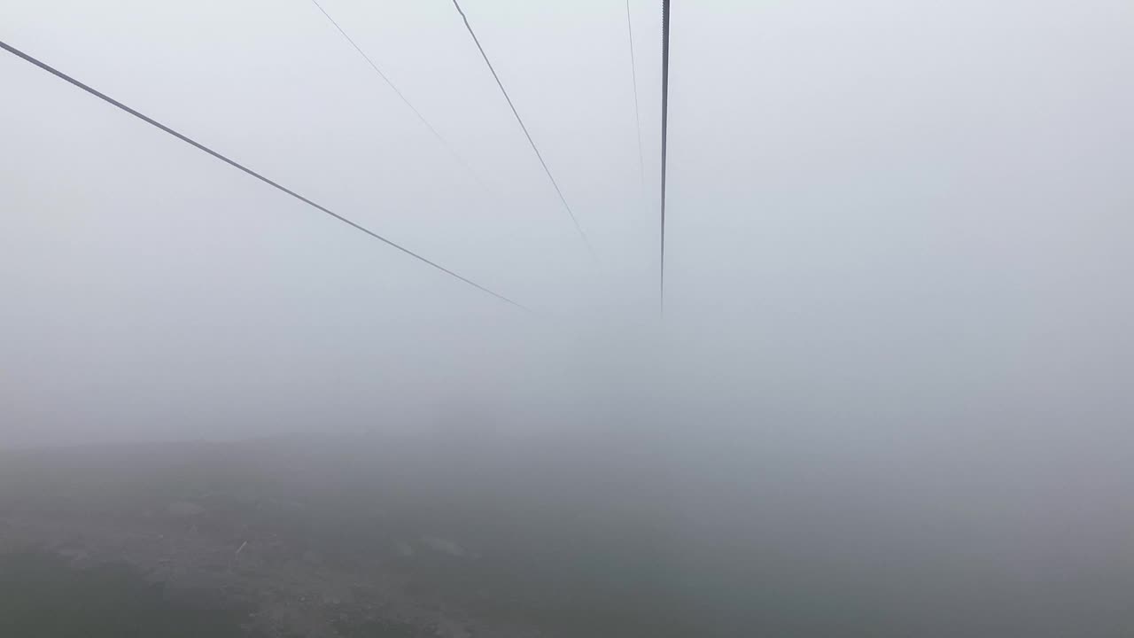 废弃的滑雪电梯。浓雾中没有人移动的空缆车视频素材