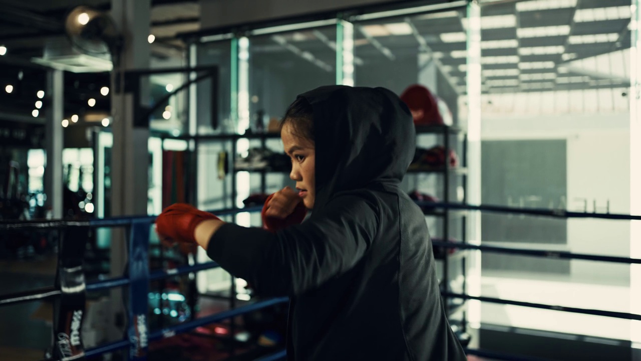 女拳击手在拳击馆里训练出拳，快速训练一系列出拳。视频下载