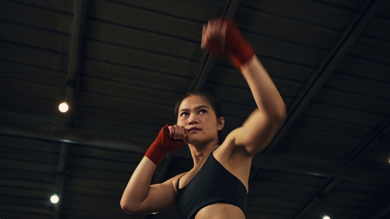 女拳击手在拳击馆里训练出拳，快速训练一系列出拳。视频素材