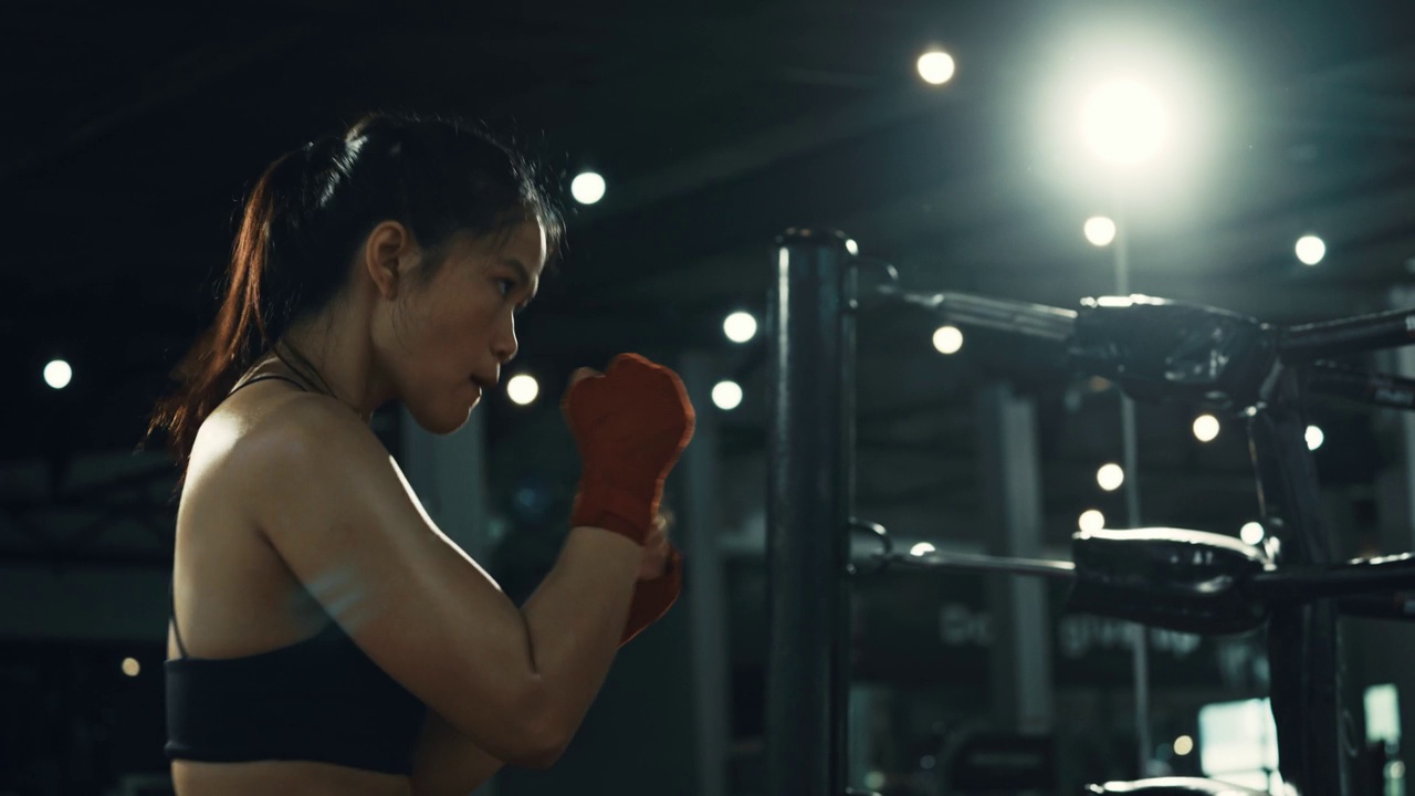 女拳击手在拳击馆里训练出拳，快速训练一系列出拳。视频下载