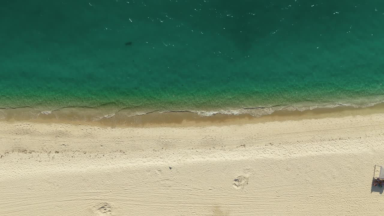 空中拍摄的空旷的沙滩和海浪的海洋。自顶向下移动镜头视频素材