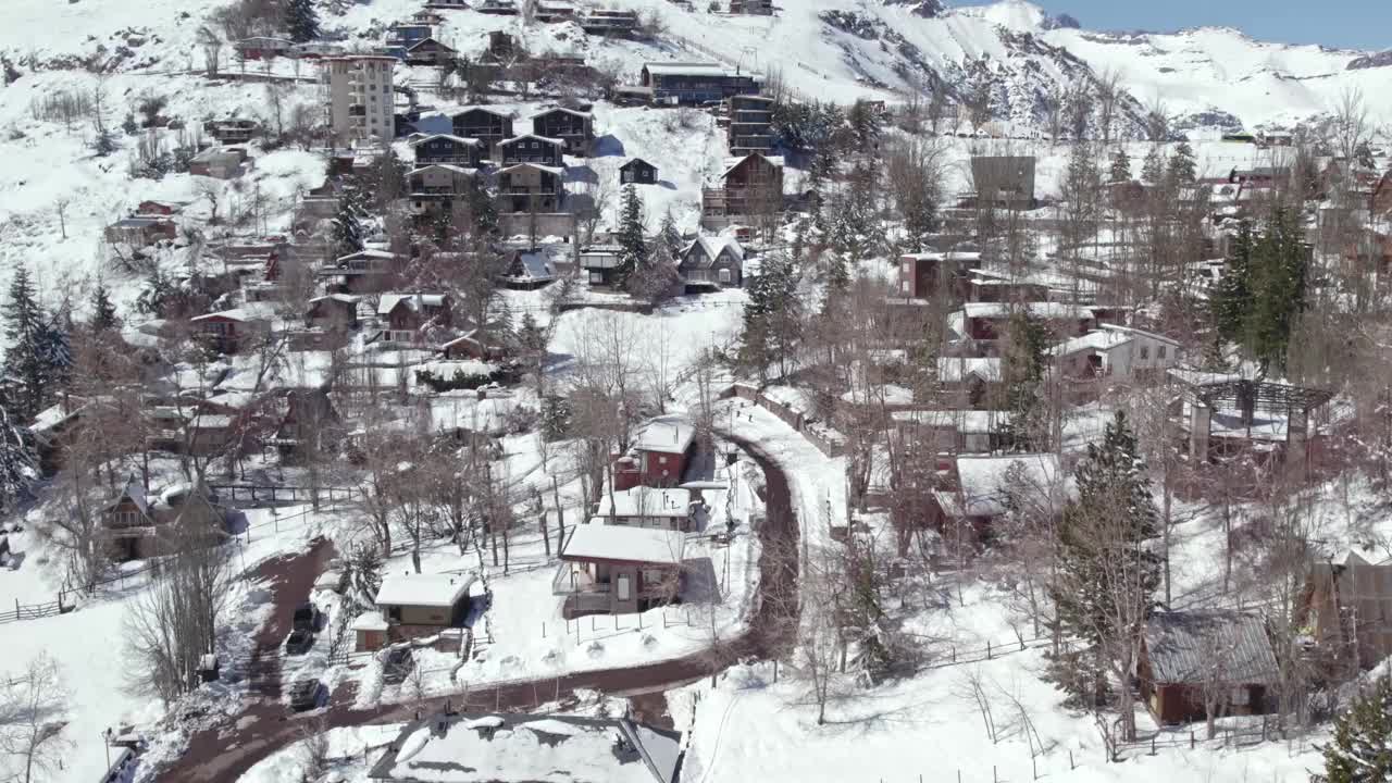 安第斯科迪勒拉滑雪胜地的山村房屋，智利圣地亚哥附近的积雪屋顶上的空中无人机视频素材