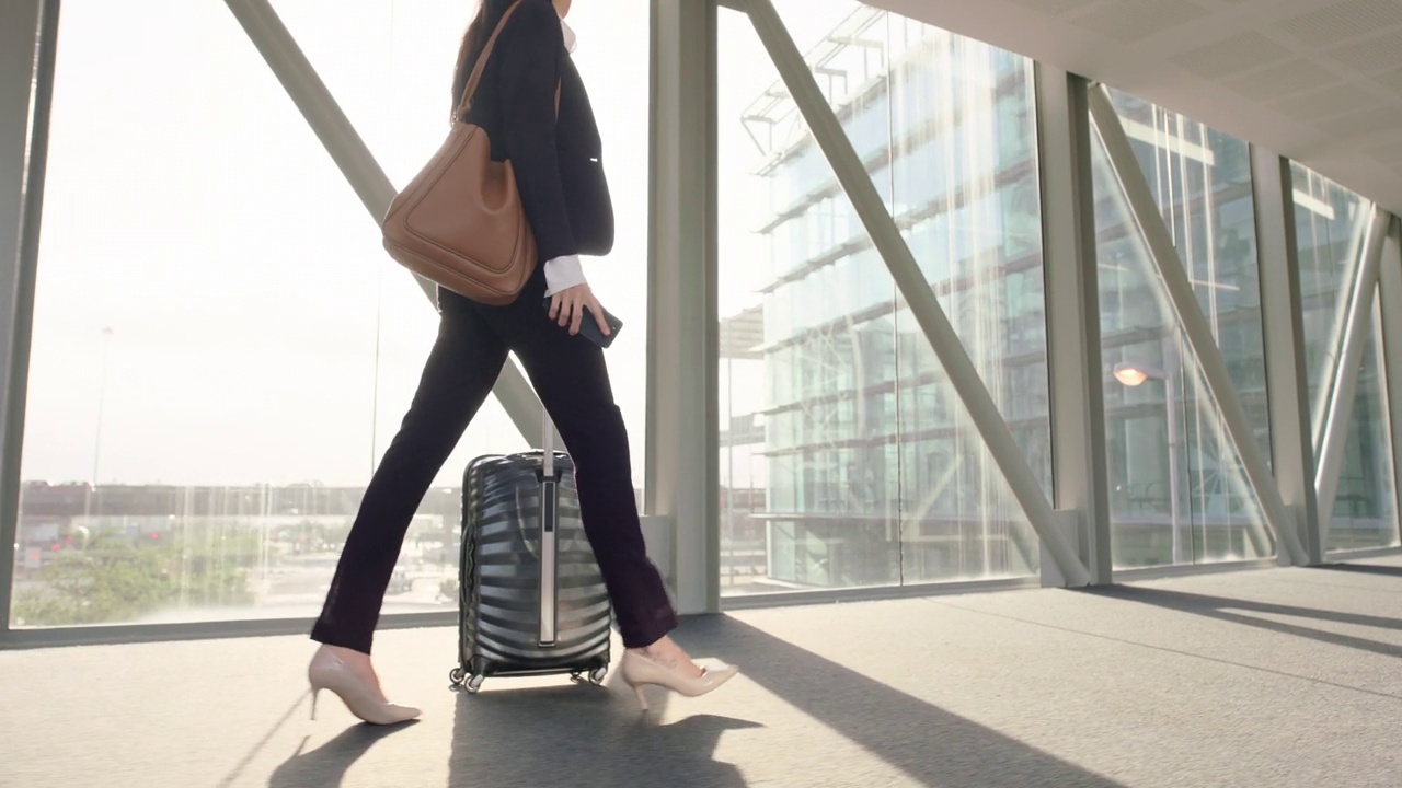 商务、妇女和步行在机场旅行，旅行和商务旅行在国际航班航站楼或大堂。员工，运输或腿的步骤移动的行李，手提箱或包视频素材