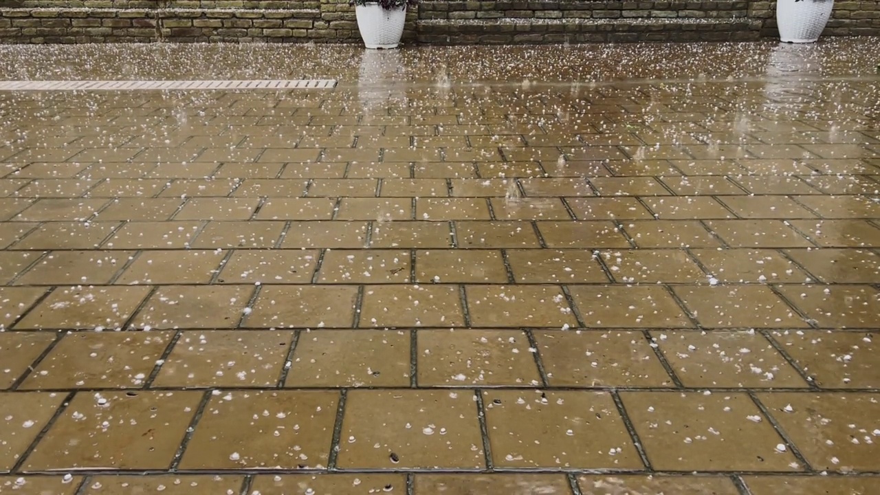 夹杂着冰雹的大雨点落在石板上。视频素材